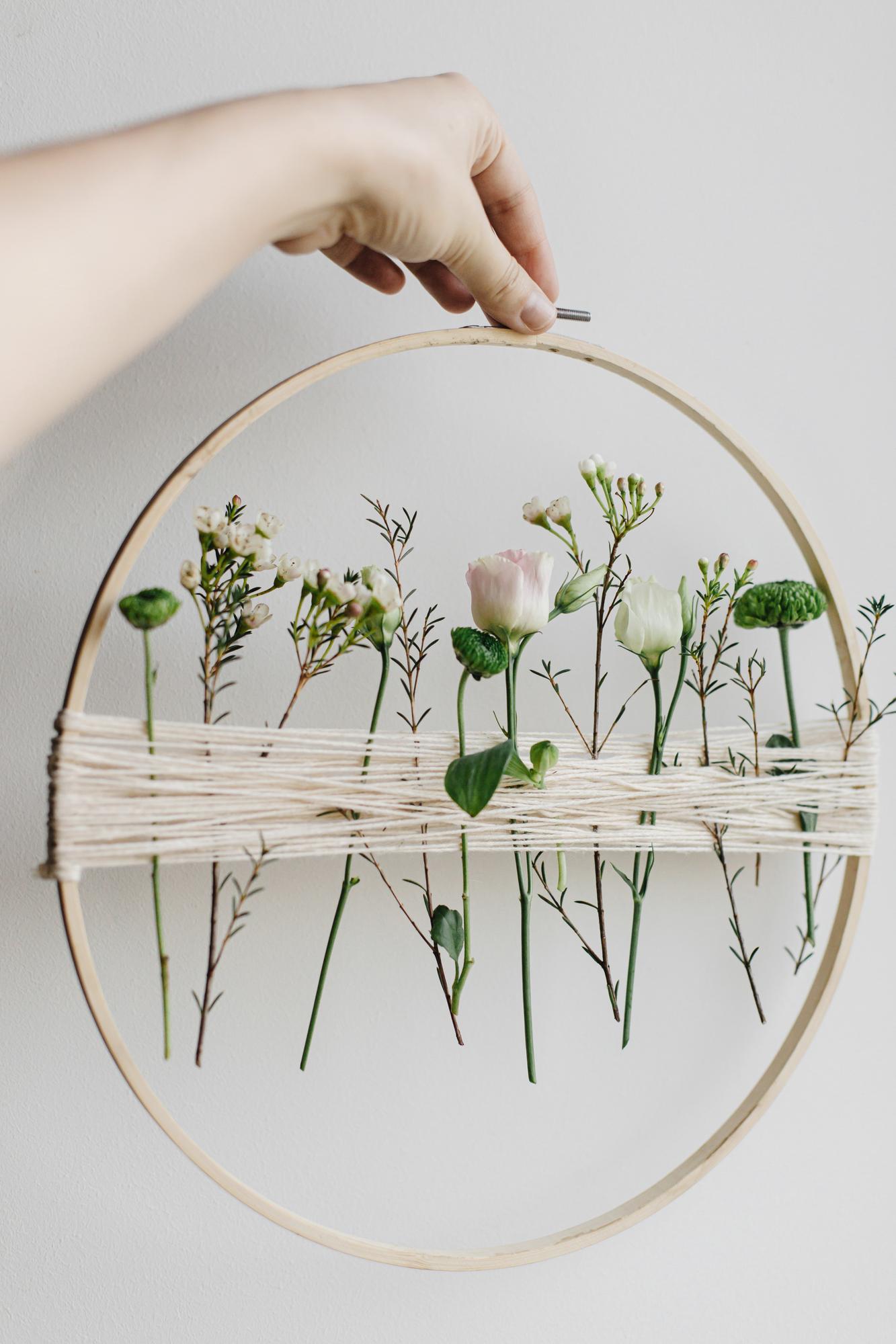 Close-up hands embroidering colorful floral pattern on fabric
